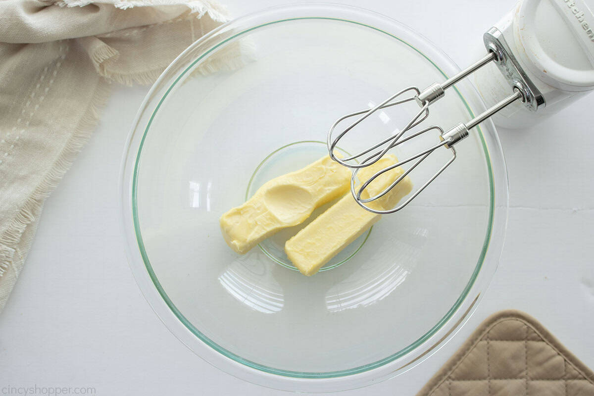 Butter in bowl with a hand mixer to the side.
