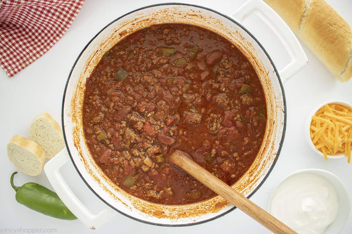 Pot of chili with toppings on the side.
