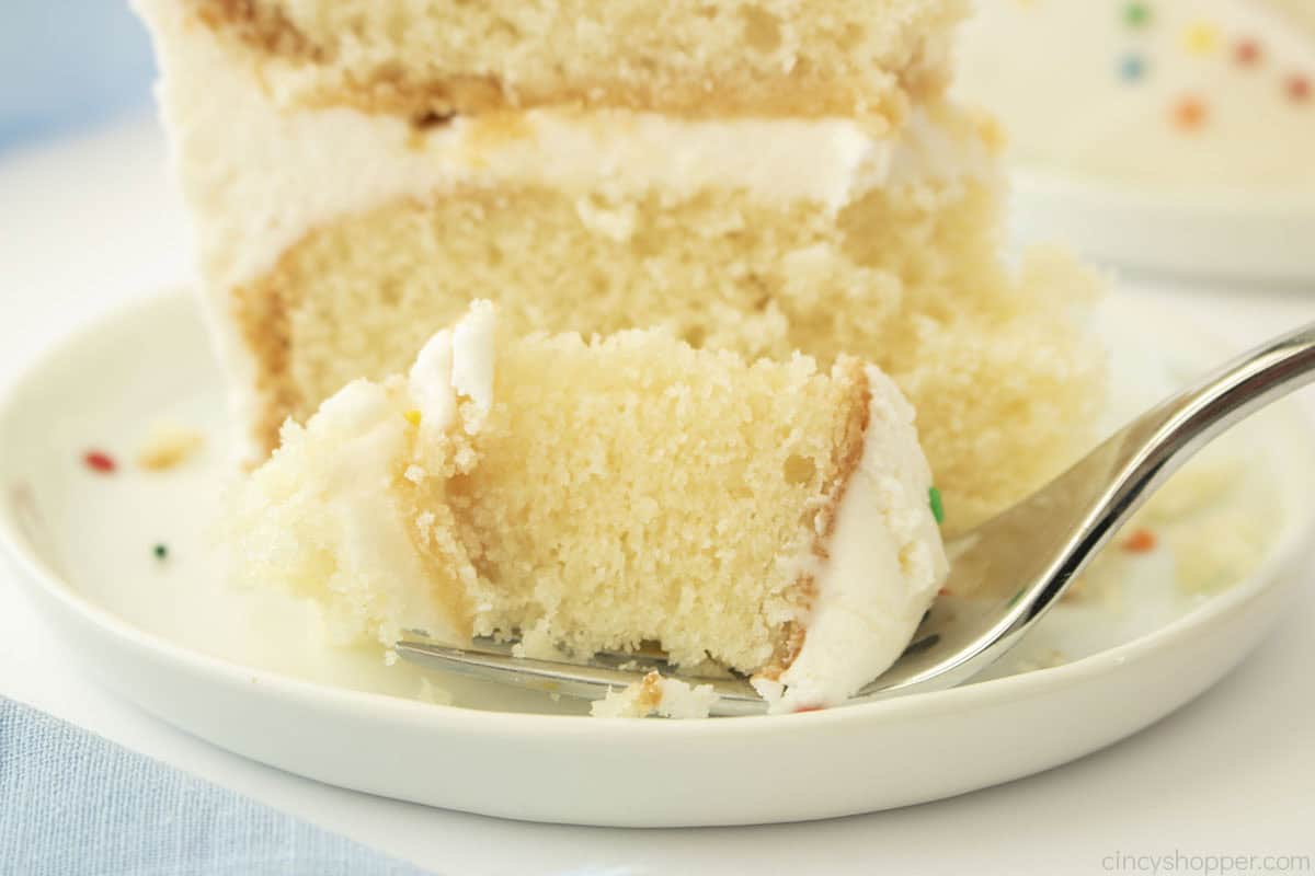 Fork with white cake on a plate.