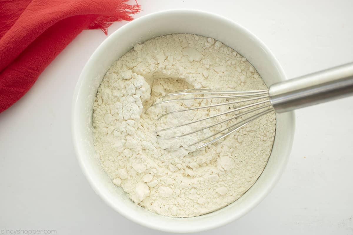 Dry apple cake ingredients in a white bowl.