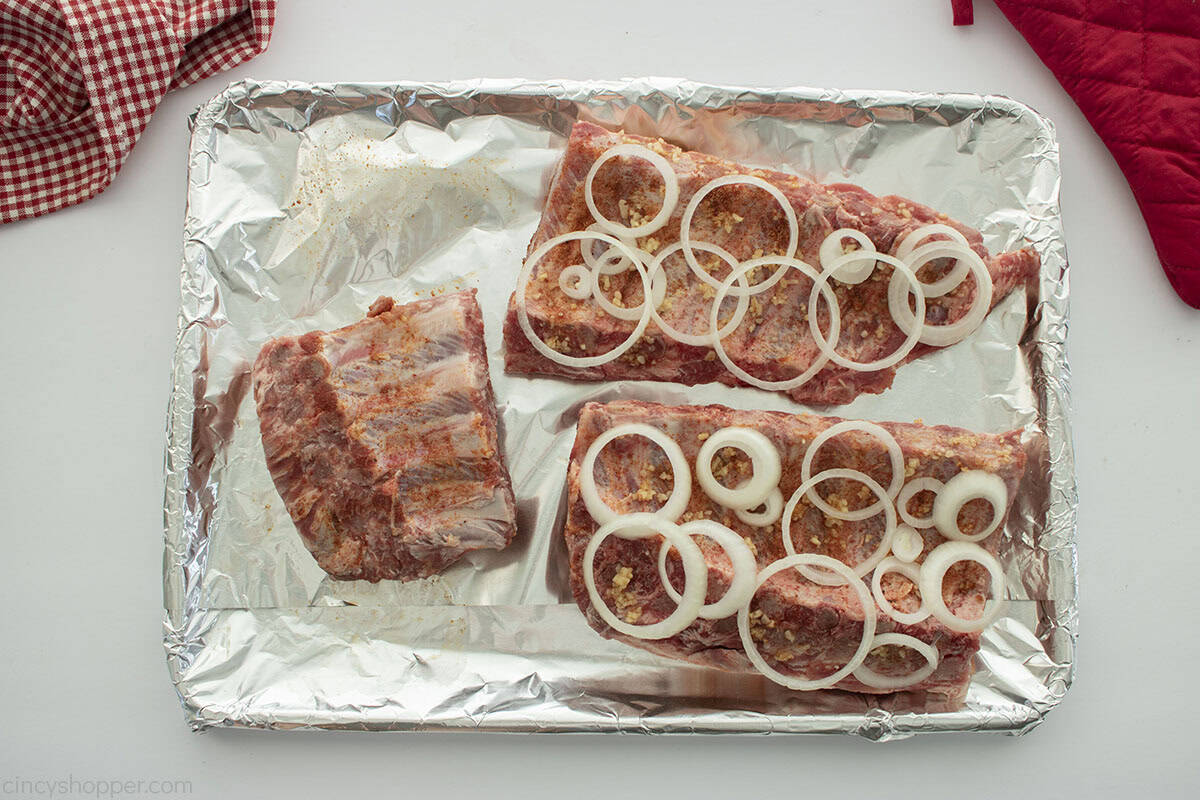 Onion and garlic added to slab of ribs.